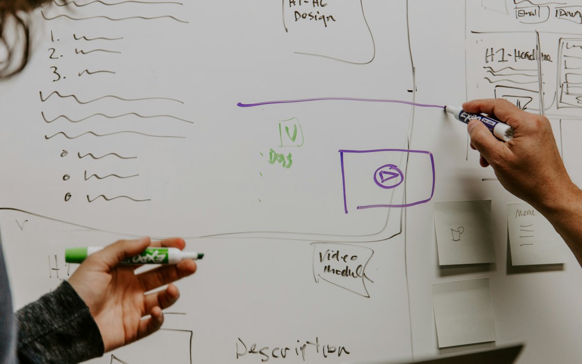 Dos personas trazando ideas en una pizarra