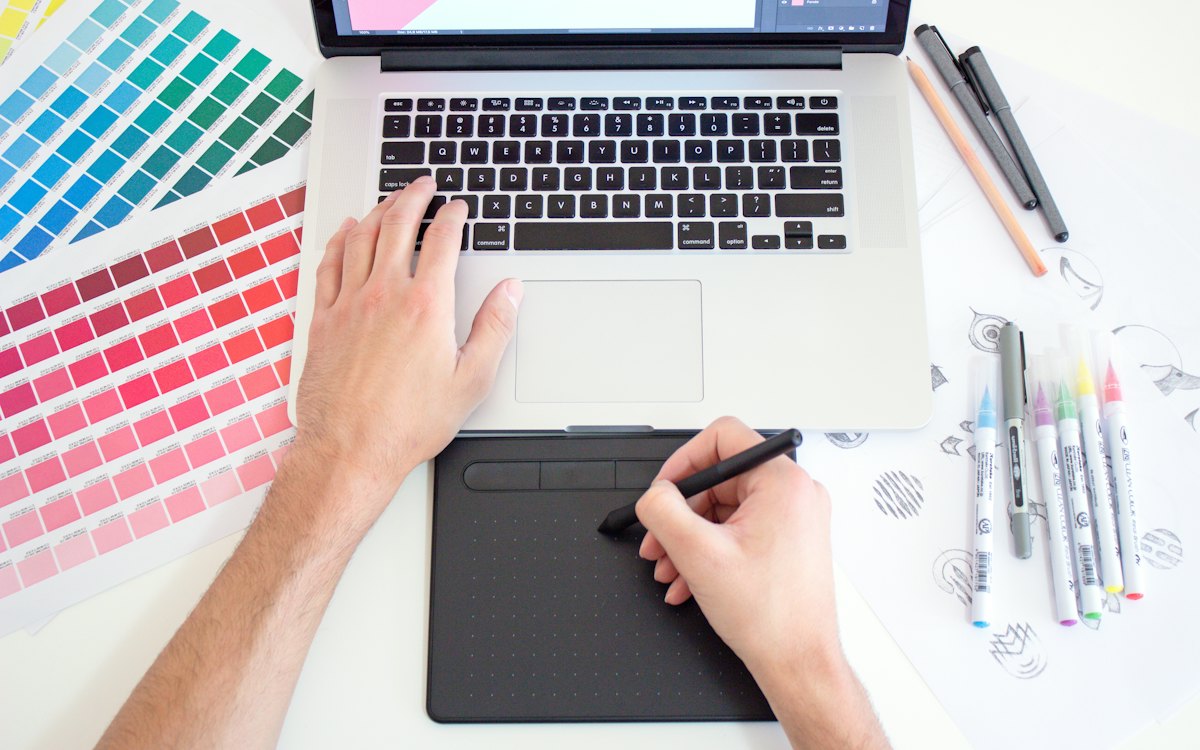 Mesa de diseño con muestras de color y una tableta gráfica
